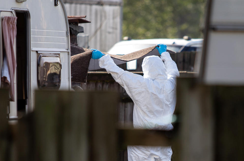 Forensic teams inspect items near a caravan close to the scene in Berkshire on Saturday morning. (SWNS)