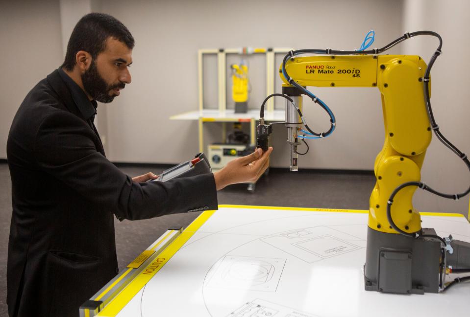 Baqer J. Aljabr, Program Manager of Advanced Manufacturing at Hocking College, works with some of the educational robots in one of the classrooms at the Fairfield County Workforce Center in Carroll last year.