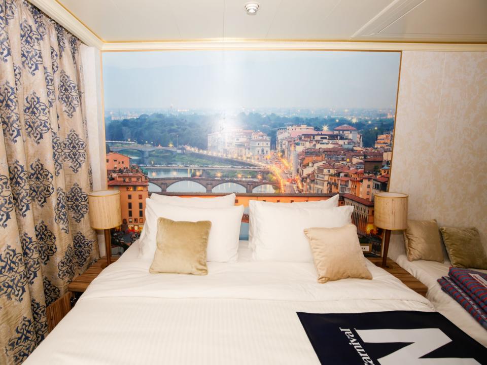 bed and picture of Italy in balcony cabin on Carnival Firenze