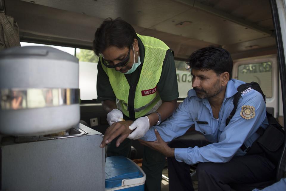 A medic tends to a police officer who was injured during clashes with supporters of Tahir ul-Qadri, Sufi cleric and leader of political party Pakistan Awami Tehreek (PAT), during the Revolution March in Islamabad August 31, 2014. (REUTERS/Zohra Bensemra)