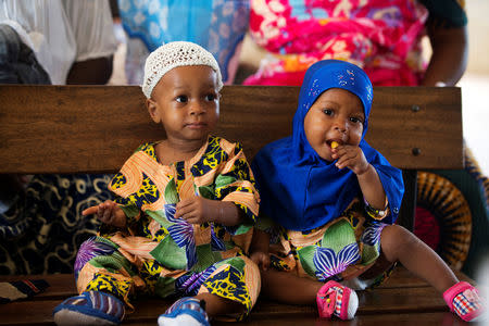 Non-identical twins Kehinde Akinbola and Taiwo Akinbola snack while waiting to receive their immunisations at the hospital in Igbo Ora, Oyo State, Nigeria April 4, 2019. PIcture taken April 4, 2019. REUTERS/Afolabi Sotunde