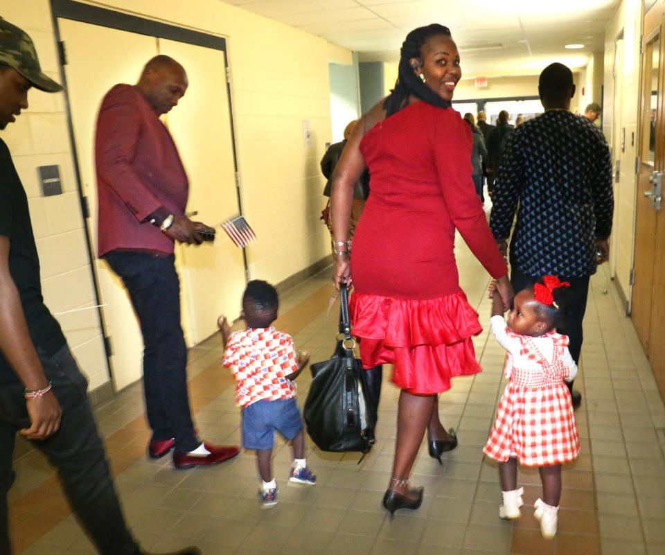Emelyne Nduwimana of East Africa glances back as she walks with her children to become a U.S. citizen at the Naturalization Ceremony at the Middle School of the Kennebunks May 3, 2024.