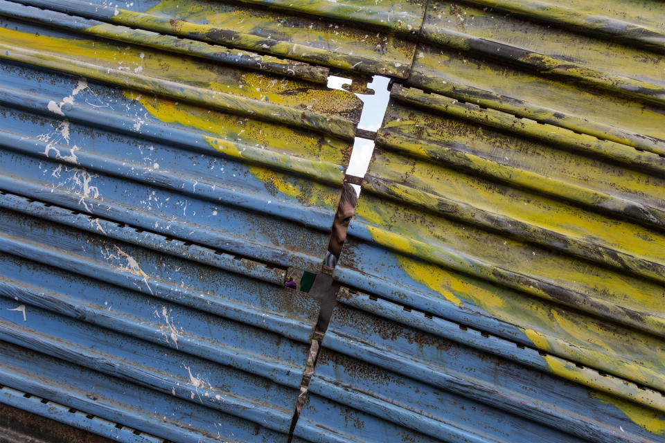 A young honduran migrant looks through the wall that divides Mexico from US on December 1, 2018. (Photo: Fabio Bucciarelli for Yahoo News)