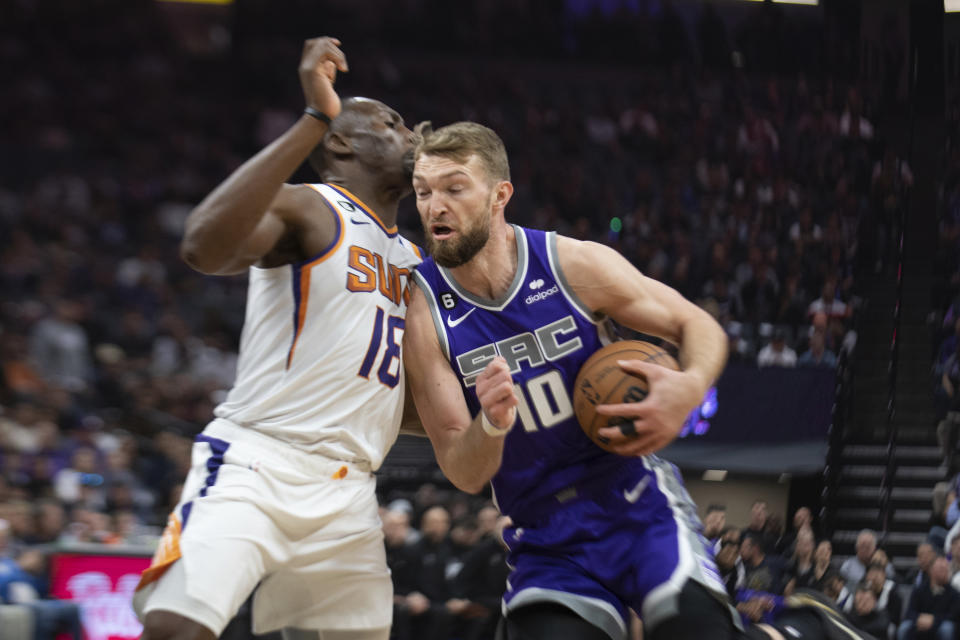 Sacramento Kings forward Domantas Sabonis (10) is defended by Phoenix Suns center Bismack Biyombo (18) as he drives to the basket in the first quarter in an NBA basketball game in Sacramento, Calif., Friday, March 24, 2023. (AP Photo/José Luis Villegas)