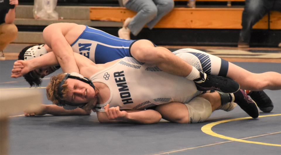 Camden Blue Devil Trey Kimball works to force the shoulders of Homer Trojan Jeffrey Stauber to the mat Saturday at Central Valley Academy. Kimball pinned Stauber in the first period of the 132-pound final at Section III's Class B tournment and earned his third sectional class championship.