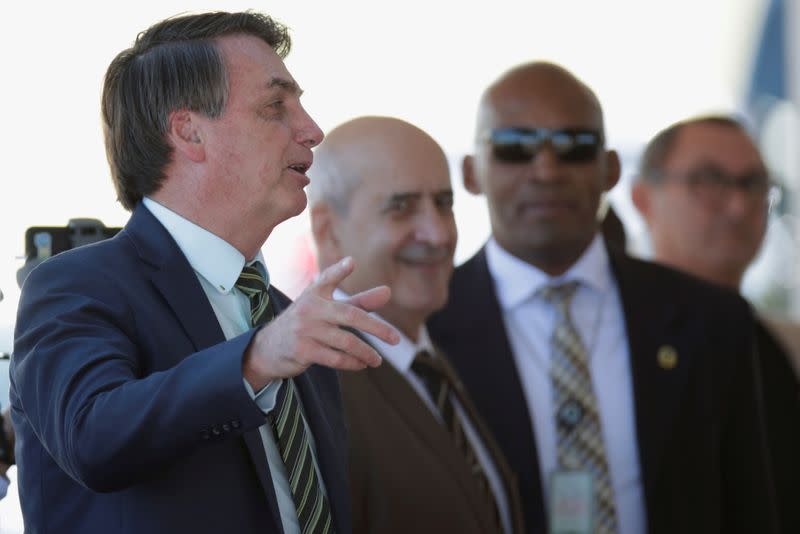 Brazil's President Jair Bolsonaro gestures while meeting supporters as he leaves at Alvorada Palace, amid coronavirus disease (COVID-19) outbreak, in Brasilia