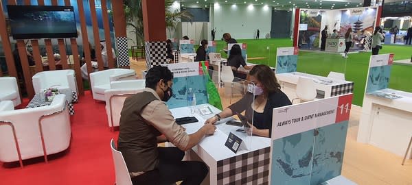 Indonesian destination's representative welcoming potential partners and tourists at one of the Indonesian Pavilion booth