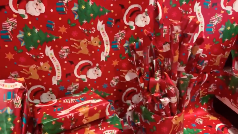 Screenshot of video showing office prank in which office walls, book, pens and every surface is wrapped in festive wrapping paper