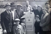 In this June 1948 photo provided by Ruth Brandspiegel, the Eisenberg and Brandspiegel families gather around the tombstone of Abraham Eisenberg at the Hallein Displaced Persons Camp in Austria. Eisenberg, father of Holocaust survivor Israel "Sasha" Eisenberg, died in a car accident shortly after World War II. Brandspiegel recently became reunited, after more than 70 years, with fellow Holocaust survivor Israel "Sasha" Eisenberg, whom she met at the displaced camp in Austria where they became friends. (Courtesy of Ruth Brandspiegel via AP)