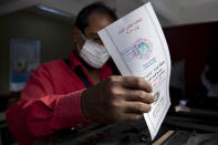 A man casts her ballot on the first day of the parliamentary election inside a polling station in Giza, Egypt, Saturday, Oct. 24, 2020. Egyptians began voting Saturday in the first stage of a parliamentary election, a vote that is highly likely to produce a toothless House of Representatives packed with supporters of President Abdel-Fattah el-Sissi. (AP Photo/Nariman El-Mofty)