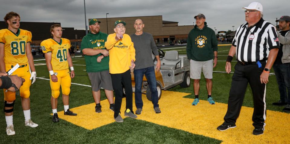 Robert Mittlestat (center) tosses the coin during opening ceremonies at the new Flat Rock Marv Mittlestat Field named after his father. Robert graduated from Flat Rock in 1953 and was on their undefeated football team in 1952.