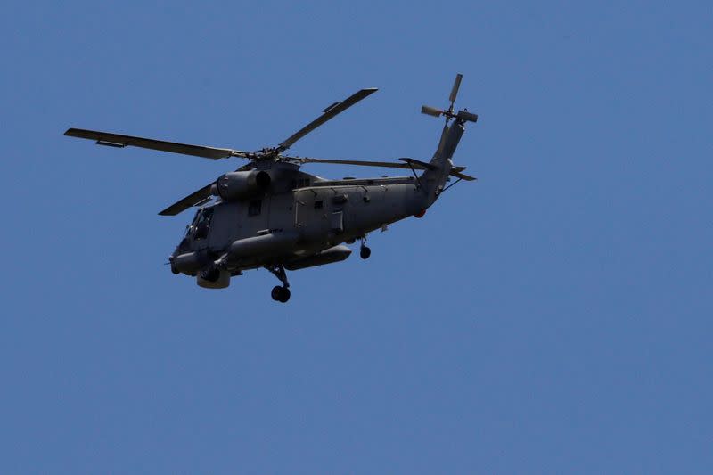 A military helicopter flies in direction to the airport during the rescue mission following the White Island volcano eruptions in Whakatane