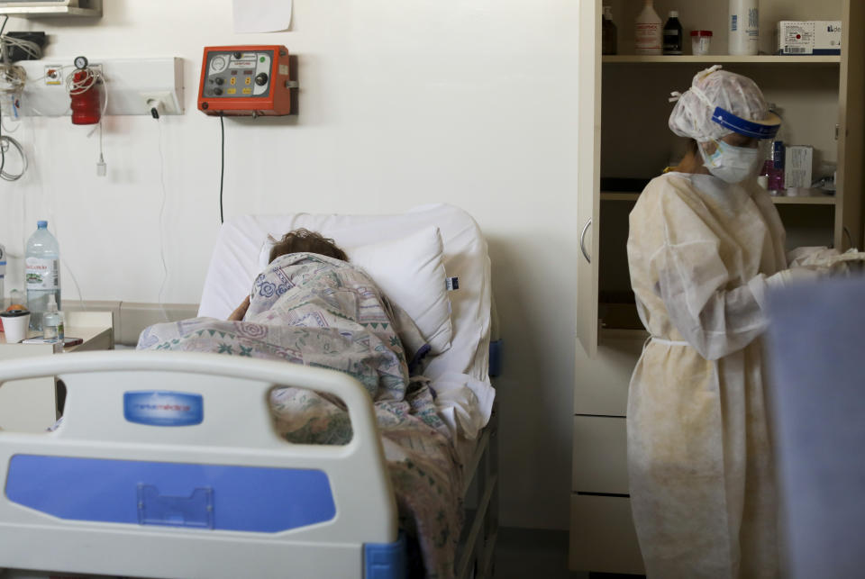 A patient with COVID-19, lies on a bed at the Eurnekian Ezeiza Hospital in Buenos Aires, Argentina, Thursday, Aug. 13, 2020. At a time when the number of deaths due to COVID-19 has increased in Argentina, several hospitals are implementing protocols on their own initiative that allow people to say goodbye to their loved ones in person, differing from the usual practice whereby the family loses all contact with the patient in hospital and he or she dies in isolation from their family. (AP Photo/Natacha Pisarenko)