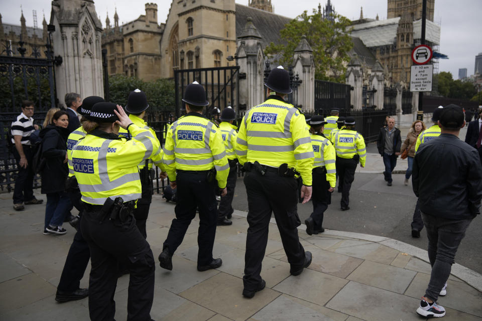 Police officers walk past the Houses of Parliament in London, Monday, Oct. 18, 2021. British lawmaker David Amess was killed on Friday during a meeting with constituents at the Belfairs Methodist church, in Leigh-on-Sea, Essex, England. (AP Photo/Matt Dunham)