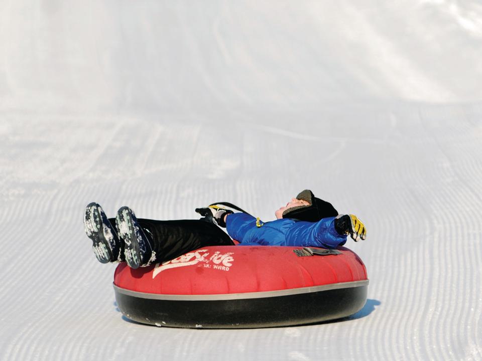 At Ski Ward in Shrewsbury,  a young boy stretches out in the tube as he flies down the slope.