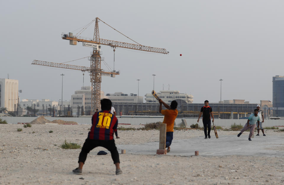 People play cricket on a patch of wasteland in Doha, Qatar, Friday, Oct. 4, 2019. The most played sport in Qatar is nowhere near the country's glitzy, air-conditioned stadiums. Cricket is king among the migrant workers who make up the majority of the gas-rich emirate's population, and Friday is game day.(AP Photo/Petr David Josek)