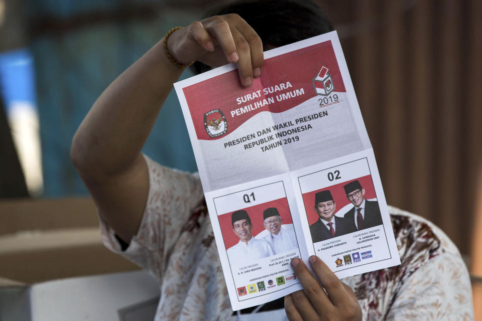 An electoral worker shows a ballot with a vote for incumbent President Joko Widodo during the vote counting at a polling station in Medan, North Sumatra, Indonesia, Wednesday, April 17, 2019. Tens of millions of Indonesians voted in presidential and legislative elections Wednesday after a campaign that pitted the moderate incumbent against an ultranationalist former general Prabowo Subianto whose fear-based rhetoric warned that the country would fall apart without his strongman leadership. (AP Photo/Binsar Bakkara)