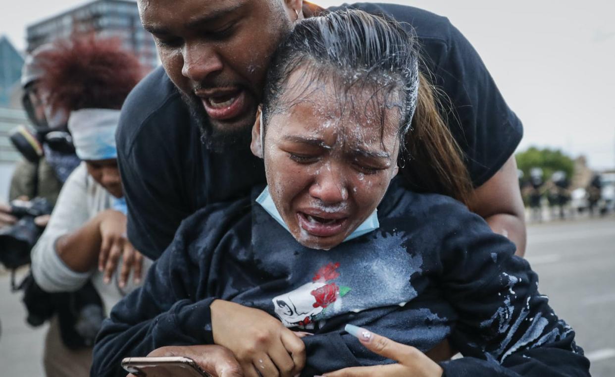 <span class="caption">A protester reacts after being hit by pepper spray from police as their group of demonstrators are detained prior to arrest at a gas station on South Washington Street, Sunday, May 31, 2020, in Minneapolis. </span> <span class="attribution"><a class="link " href="http://www.apimages.com/metadata/Index/APTOPIX-America-Protests-Minneapolis/26d3b4099da44eee84e05ef34e2f92a6/6/0" rel="nofollow noopener" target="_blank" data-ylk="slk:John Minchillo/AP Photo;elm:context_link;itc:0;sec:content-canvas">John Minchillo/AP Photo</a></span>