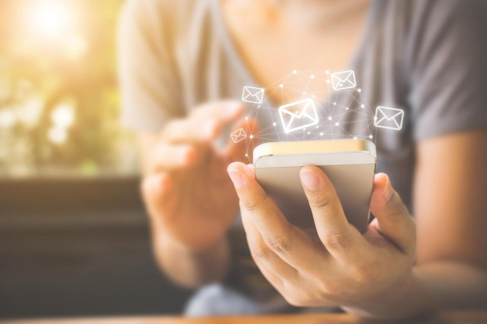 A woman sending e-mails from her phone.