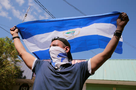 A demonstrator holds a national flag during a march to mark the one year anniversary of the protests against Nicaraguan President Daniel Ortega's government, in Managua, Nicaragua April 17, 2019.REUTERS/Oswaldo Rivas