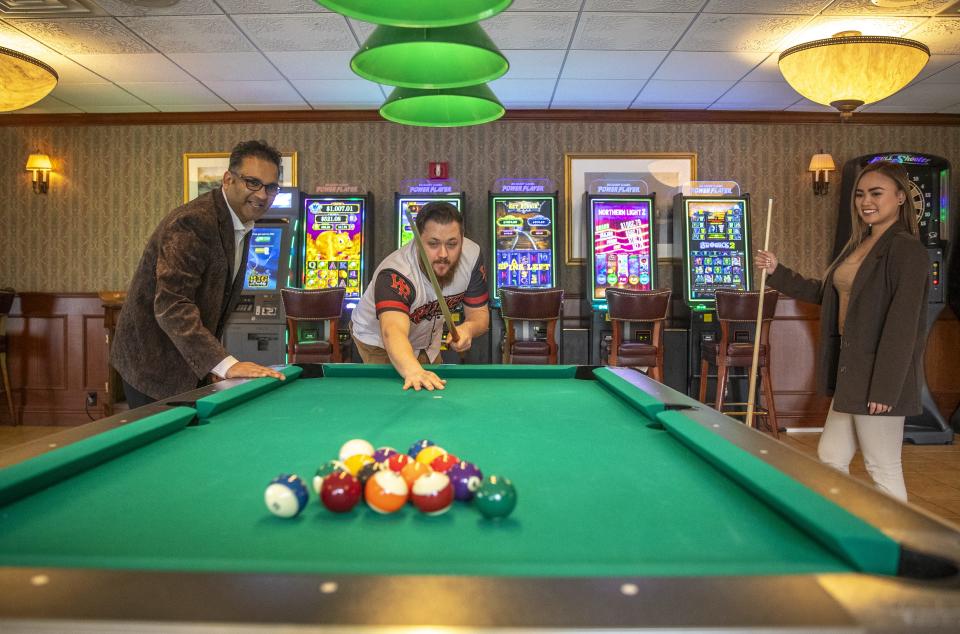 Hotel Mead Resorts & Convention Centers owner Sean Patel, Food and Beverage Manager Adam Serianni and General Manager Lucky Richardson play at one of the new pool tables surrounded by the new gaming and dartboard kiosks in the hotel's Grand Avenue Tavern on Tuesday in Wisconsin Rapids.