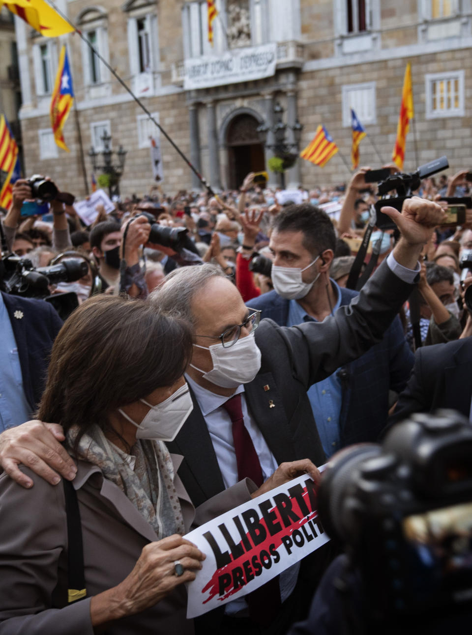 Catalonia's outgoing regional president, Quim Torra, waves to Catalan pro-independence demonstrators as he leaves the Generalitat Palace in Barcelona, Spain on Monday, Sept. 28, 2020. Spain's Supreme Court has barred Catalonia's regional president from his office for refusing to remove a banner calling for the release of separatist leaders from prison that was displayed on a public building ahead of the 2019 general election (AP Photo/Emilio Morenatti)