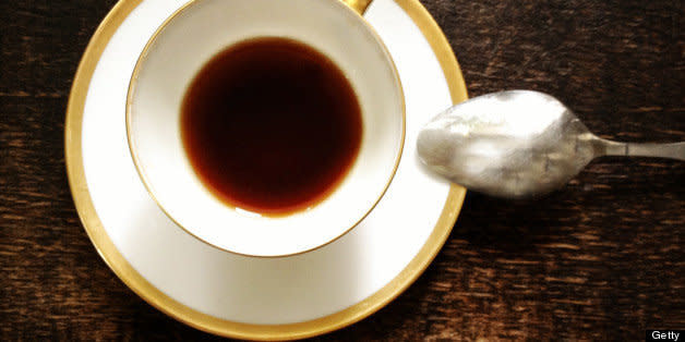 Espresso cup, saucer and spoon from above on a dark wooden surface. (Photo: )