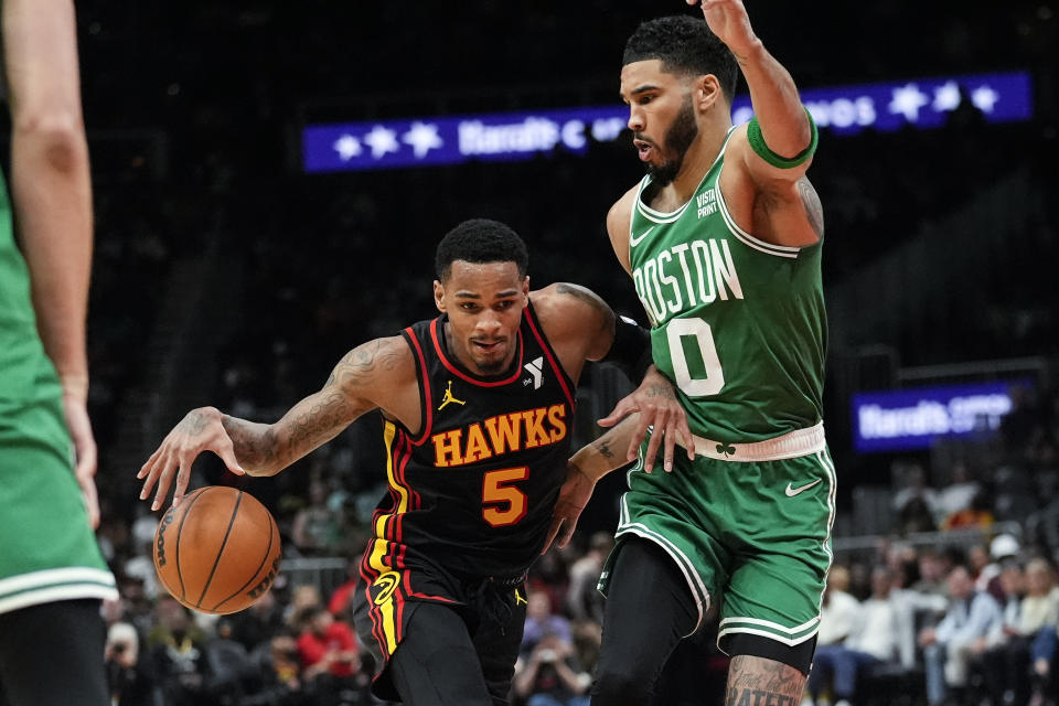 Atlanta Hawks guard Dejounte Murray (5) drives against Boston Celtics forward Jayson Tatum (0) during the first half of an NBA basketball game Thursday, March 28, 2024, in Atlanta. (AP Photo/John Bazemore)