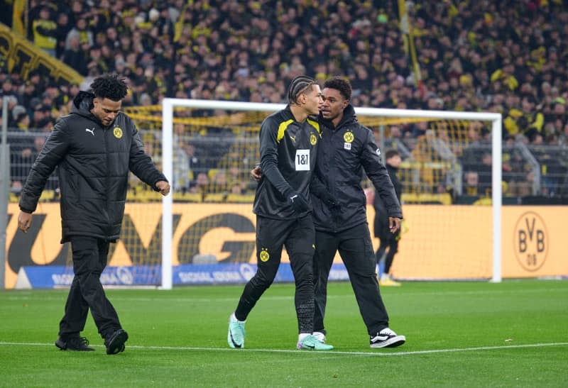 Dortmund's U-17 world champion Almugera Kabar (L-R), Paris Brunner and Charles Herrmann walk across the pitch ahead of the German Bundesliga soccer match between Borussia Dortmund and RB Leipzig at Signal Iduna Park. Borussia Dortmund are poised to offer Germany Under-17 World Cup winner Brunner a professional contract. Bernd Thissen/dpa