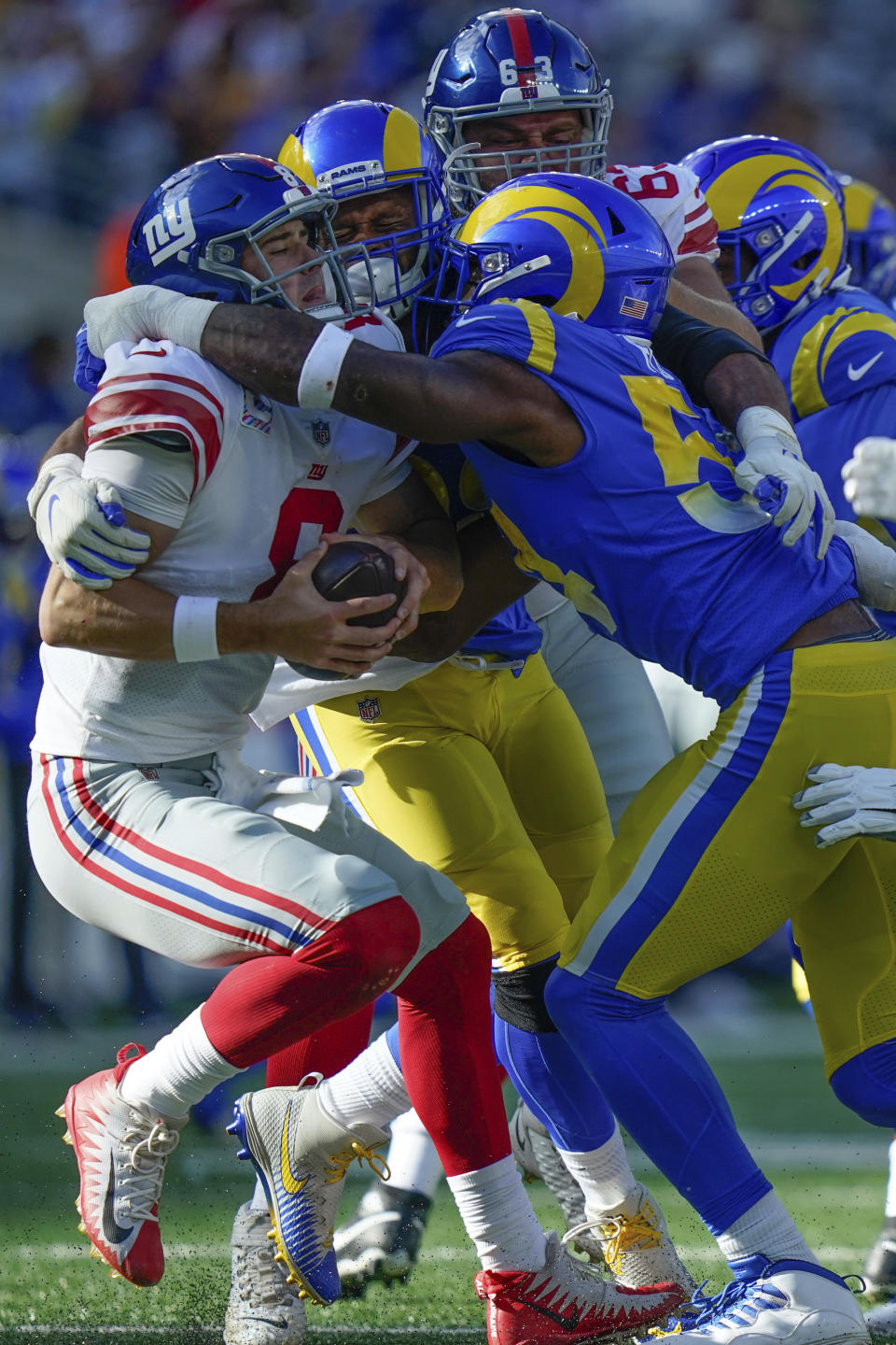 New York Giants quarterback Daniel Jones, left, is tackled by Los Angeles Rams defenders during the second half of an NFL football game, Sunday, Oct. 17, 2021, in East Rutherford, N.J. (AP Photo/Frank Franklin II)