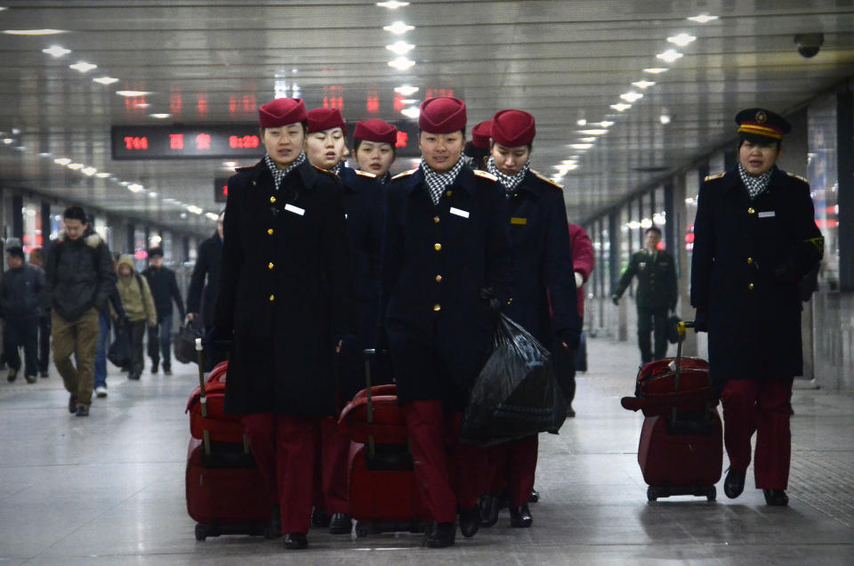 Train stewardesses make their way at the Beijing west railway station in Beijing on December 26, 2012. China on December 26 started service on the world's longest high-speed rail route, the latest milestone in the country's rapid and sometimes troubled super fast rail network. AFP PHOTO / WANG ZHAO