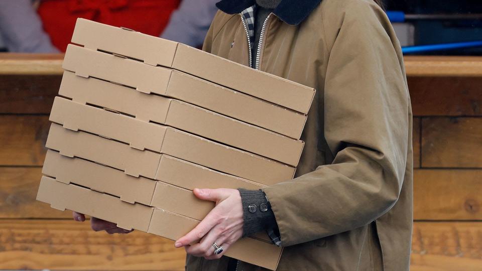 kate middleton in barbour coat holding pizza boxes 