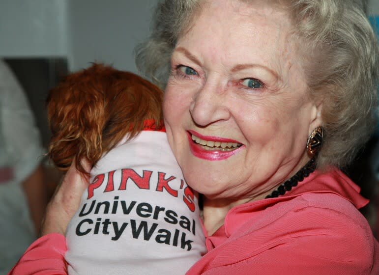 A woman hugs a dog close to her face