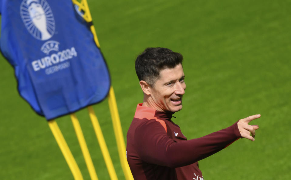 El jugador lesionado de Polonia Robert Lewandowski señala durante una sesión de entrenamiento de la selección nacional en el Eilenriedestadion en Hannover, Alemania, el miércoles 12 de junio de 2024. (Julian Stratenschulte/dpa vía AP)