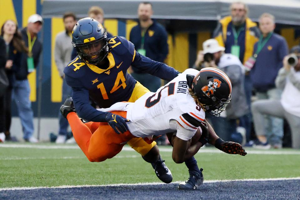 Oklahoma State's Jaden Bray (5) catches a pass for a touchdown as West Virginia's Malachi Ruffin (14) covers during the second half of an NCAA college football game Saturday, Oct. 21, 2023, in Morgantown, W.Va. (AP Photo/Chris Jackson)