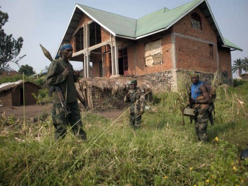 Rebels of the M23 group stand near a deserted house after their troops entered the town of Rutshuru that had already been deserted by the Congolese army, near the Ugandan border. Rebel fighters in the Democratic Republic of Congo seized control Sunday of more towns in the country's east, but said they would cede most of their gains to UN peacekeepers and police