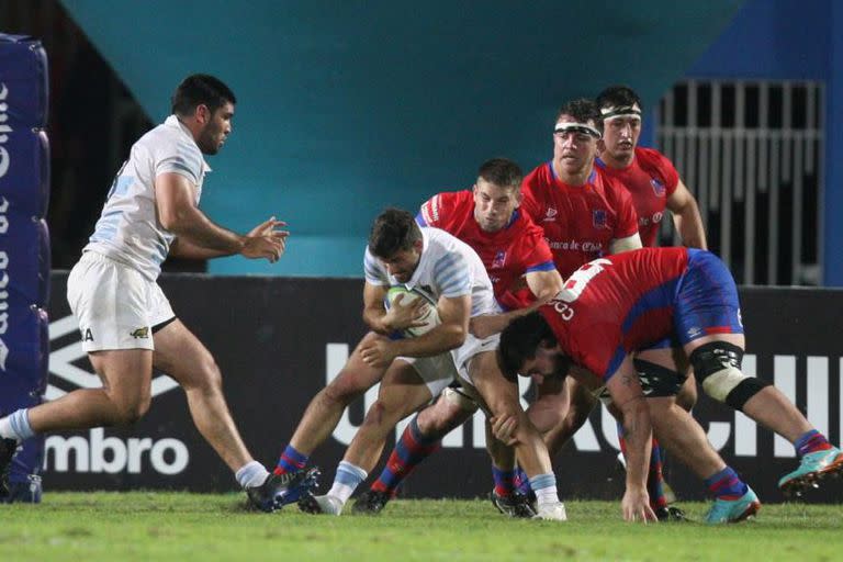 Rafael Iriarte resiste con la pelota mientras llega en ayuda Joaquín Oviedo; hubo buenas producciones de ambos en el 40-13 de Argentina XV a Chile en Antofagasta.