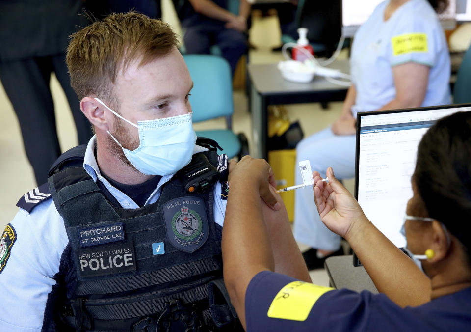 New South Wales Police officer Lachlan Pritchard receives the Pfizer vaccine at the Royal Prince Alfred Hospital Vaccination Hub in Sydney, Australia, Monday, Feb. 22, 2021. Australia has started its COVID-19 vaccination program days after its neighbor New Zealand with both governments deciding their pandemic experiences did not require regulation short cuts. (Toby Zerna/Pool Photo via AP)