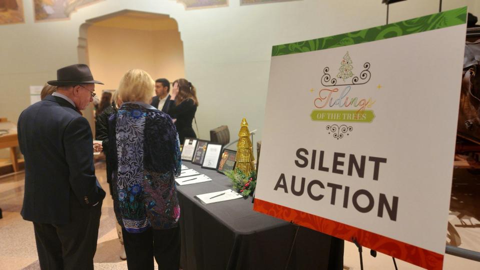 Attendees look over silent auction items Thursday night at the 2nd annual Tidings of the Trees fundraiser event at the Panhandle-Plains Historical Museum in Canyon.