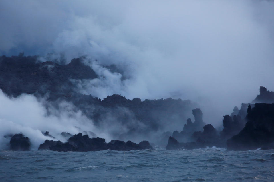 <p>Clouds of laze, composed of steam, acid and volcanic glass, rise from lava flowing into the Pacific Ocean in the Kapoho area, on the outskirts of Pahoa, during ongoing eruptions of the Kilauea Volcano in Hawaii, June 7, 2018. (Photo: Terray Sylvester/Reuters) </p>