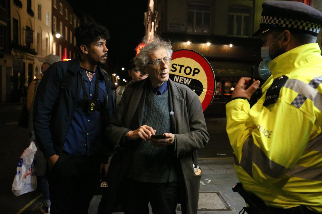 Police chat with Piers Corbyn in Soho on Friday night (PA)