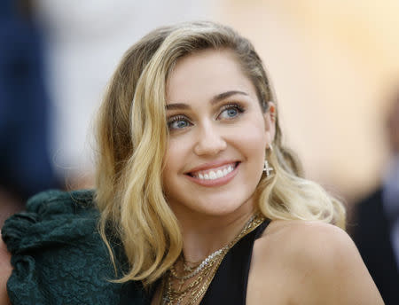 FILE PHOTO: Singer Miley Cyrus arrives at the Metropolitan Museum of Art Costume Institute Gala (Met Gala) to celebrate the opening of “Heavenly Bodies: Fashion and the Catholic Imagination” in the Manhattan borough of New York, U.S., May 7, 2018. REUTERS/Eduardo Munoz/File Photo