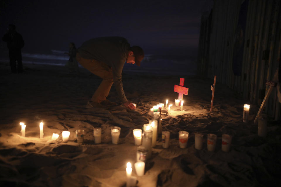 Candles are placed next to the border fence that separates Mexico from the United States, in memory of migrants who have died during their journey toward the U.S., in Tijuana, Mexico, late Saturday, June 29, 2019. (AP Photo/Emilio Espejel)