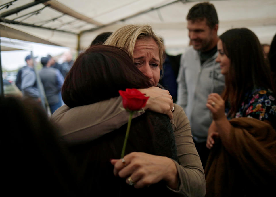 Relatives embrace during the burial of Rhonita Miller and her children – Howard, Kristal, Titus, and Tiana.