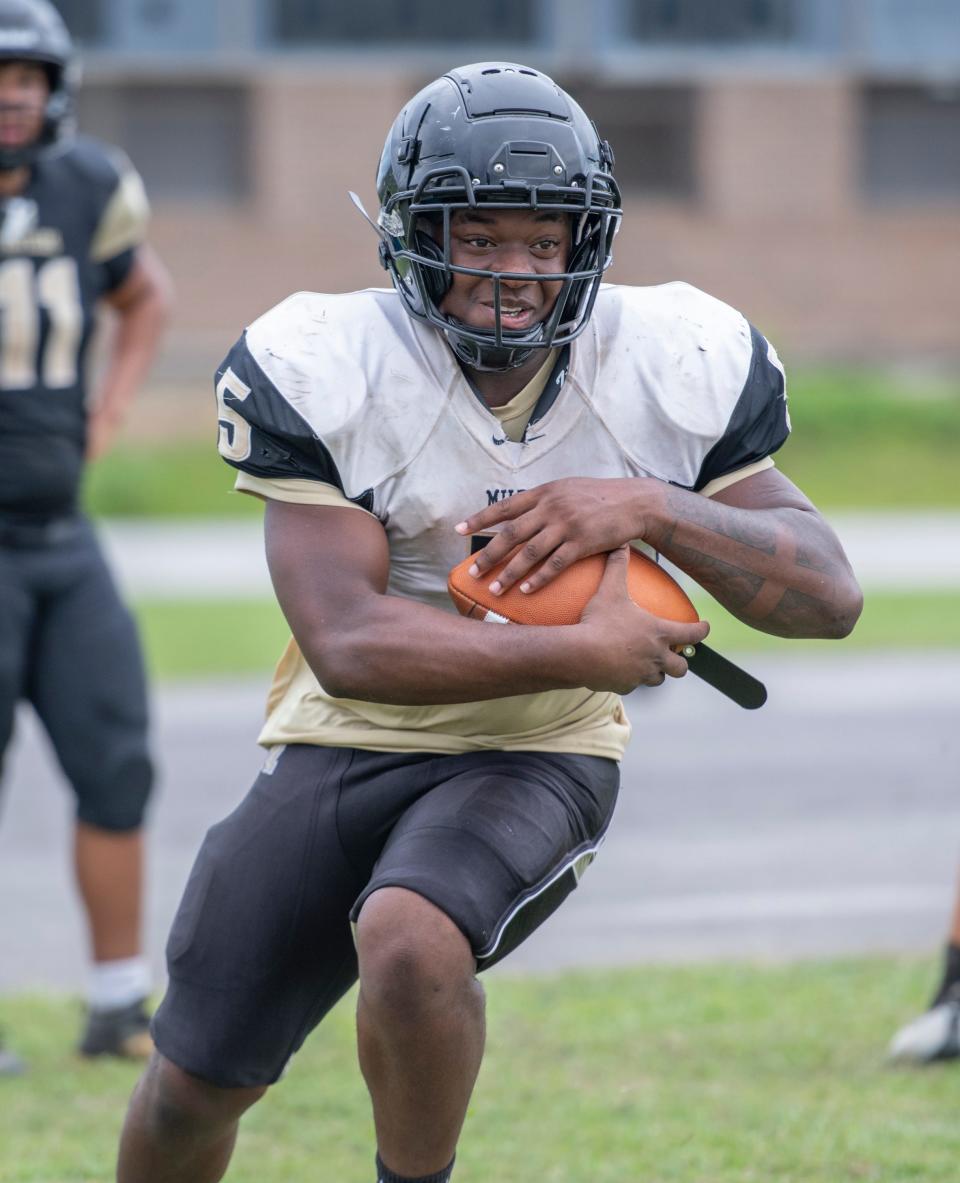 Tyree Haynes (5) carries the ball during football practice at Milton High School on Monday, Aug. 8, 2022.