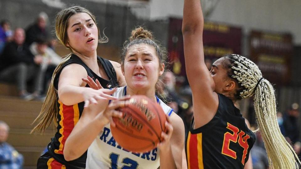 Caruthers’ Krissy Turman, center, drives between Chico High’s Taylee Clements, left, and Talysha Wilkerson on her way to the hoop during their game in the annual Nike Central Valley Showdown girls basketball tournament at Clovis West High School on Friday, Dec. 3, 2021.