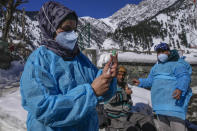 Masrat Farid, a healthcare worker, prepares to administer a booster dose of the Covishield vaccine to Ghulam Hassan on a snow covered road during a COVID-19 vaccination drive in Gagangeer, northeast of Srinagar, Indian controlled Kashmir, Jan. 12, 2022. (AP Photo/Dar Yasin)