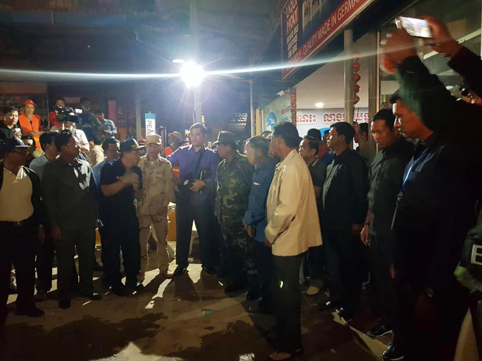 In this Sunday, June 23, 2019, photo provided by Preah Sihanouk provincial authorities, Cambodia's Prime Minister Hun Sen, center right, visits a site of a building collapse in Preah Sihanouk province, Cambodia. Rescuers on Monday were continuing to search the rubble of a building that collapsed while under construction in a Cambodia beach town, killing dozens of workers as they slept in the unfinished condominium that was doubling as their housing. (Preah Sihanouk provincial authorities via AP)