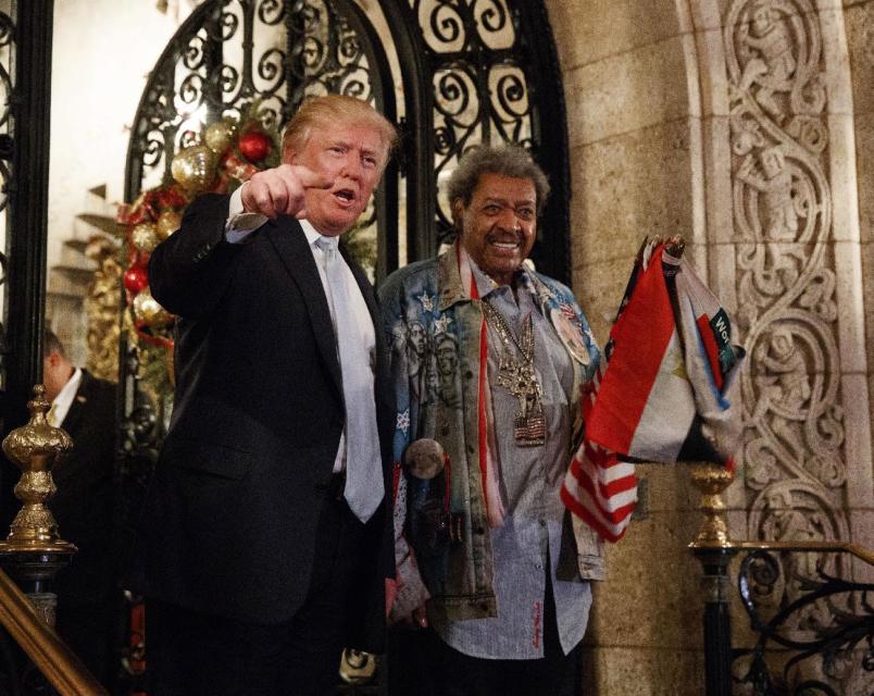 FILE - In this Wednesday, Dec. 28, 2016, file photo, President-elect Donald Trump, left, stands with boxing promoter Don King as he speaks to reporters at Mar-a-Lago, in Palm Beach, Fla. Many of Trump’s cultural touchstones, which he’d frequently namedrop at campaign rallies and on Twitter, including Don King, were at their peak in the 1980s, the decade that Trump’s celebrity in New York rose, Trump Tower was built, “The Art of the Deal” was published and he first flirted with running for public office. (AP Photo/Evan Vucci, File)