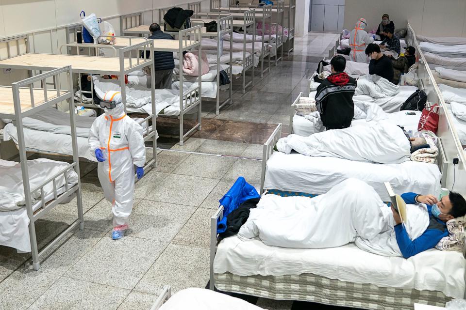 Medical workers in protective suits attend to patients at the Wuhan International Conference and Exhibition Center, which has been converted into a makeshift hospital to receive patients with mild symptoms caused by the novel coronavirus, in Wuhan, Hubei province, China February 5, 2020. China Daily via REUTERS 